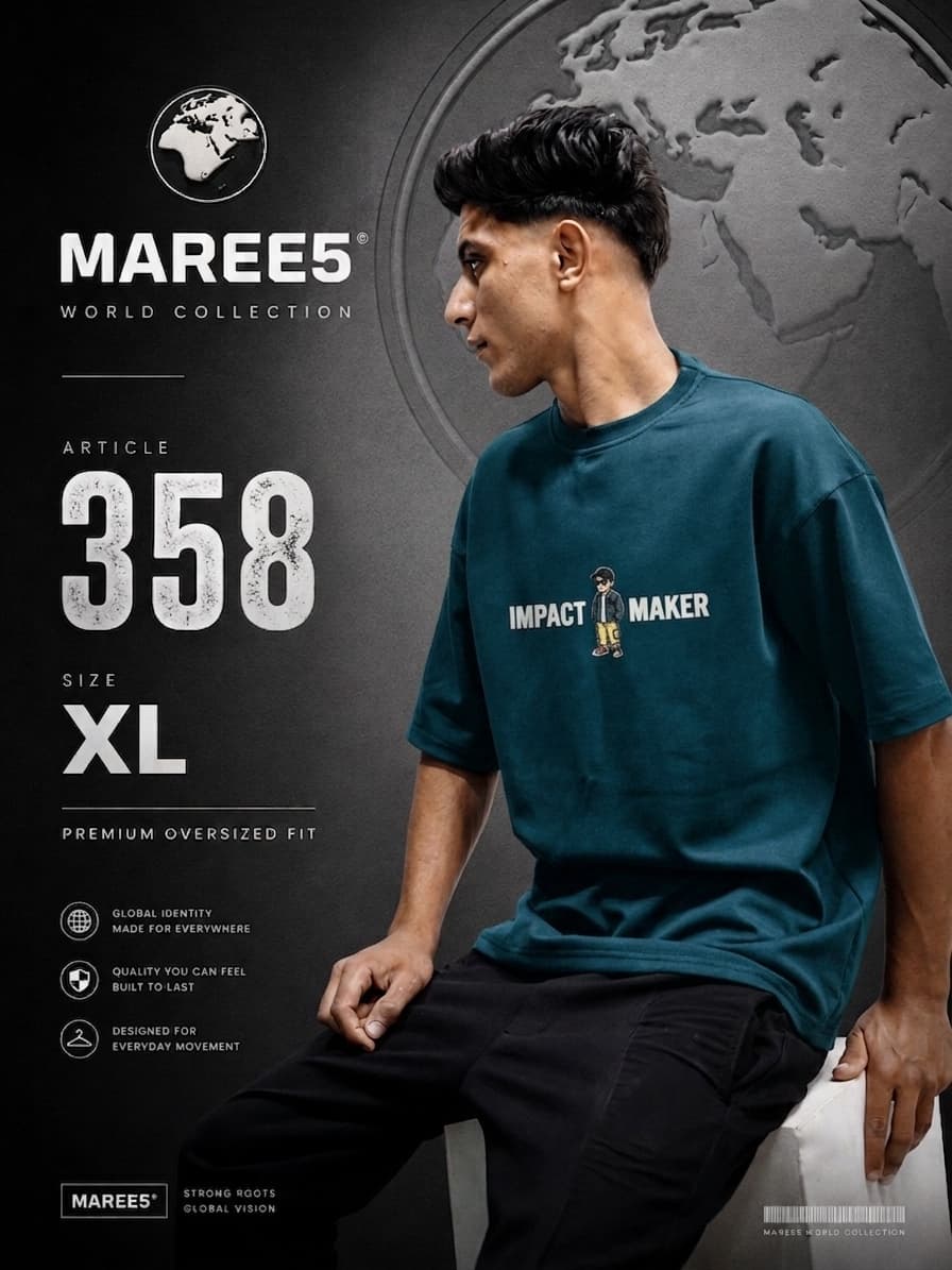 رجل يرتدي تيشيرت فضفاض من ماركة MAREE5 بلون أزرق مخضر مع عبارة "IMPACT MAKER".